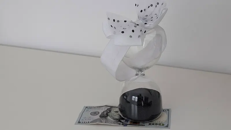 inverti hoy, dinero dolares debajo de reloj de arena